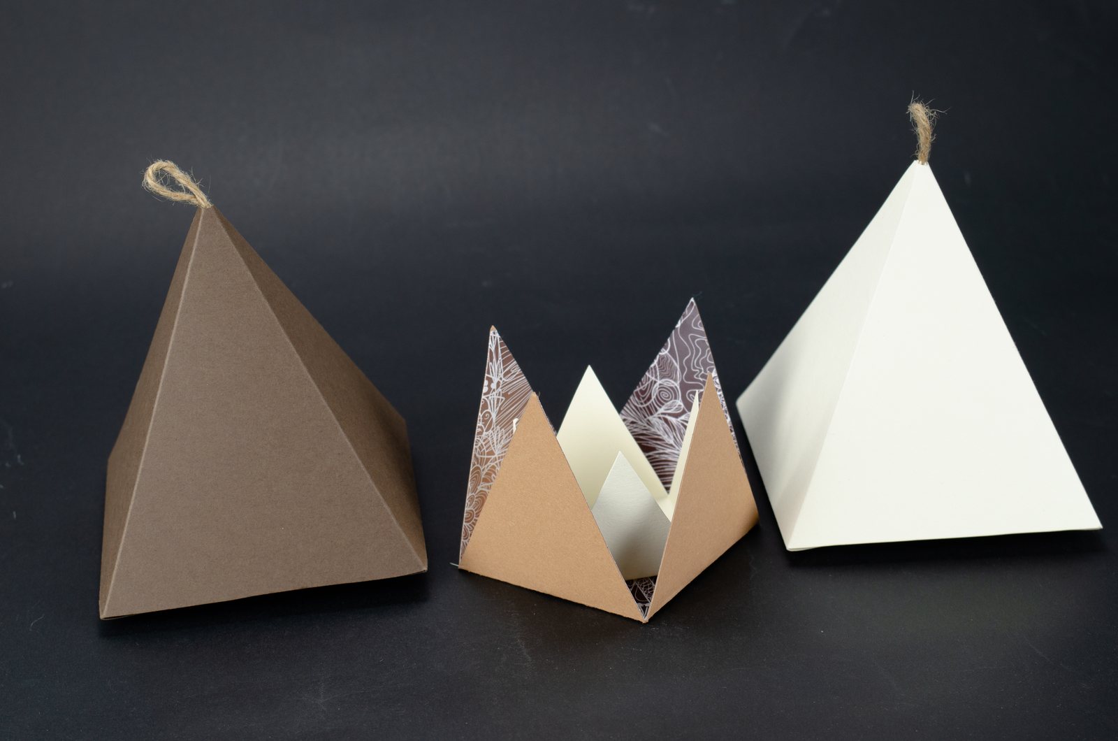 Three triangular boxes on black: brown, patterned and white