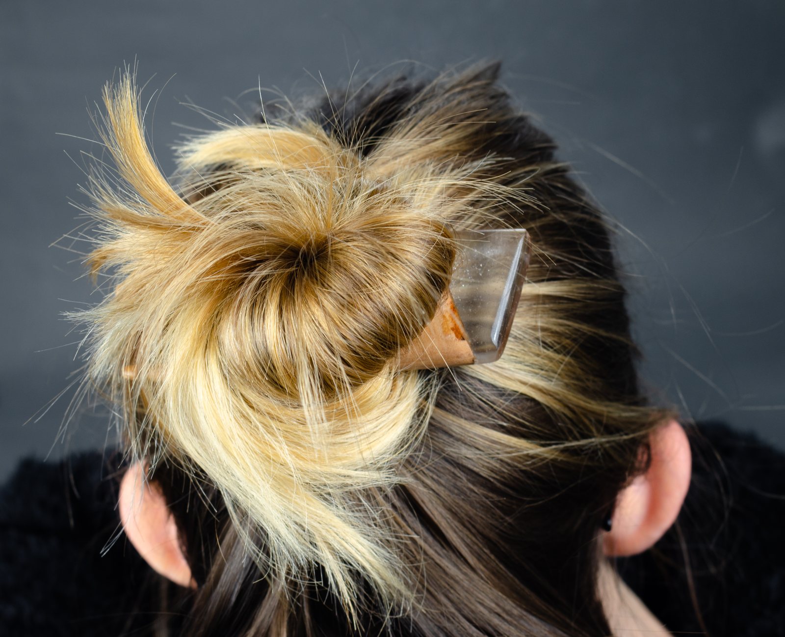 A wooden hairpin worn in a bun