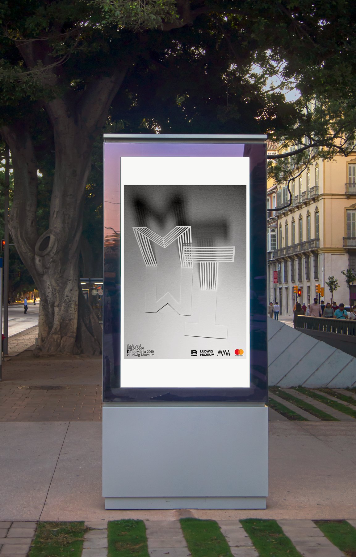 Mockup: the grey TipoMánia poster on a street advertising column
