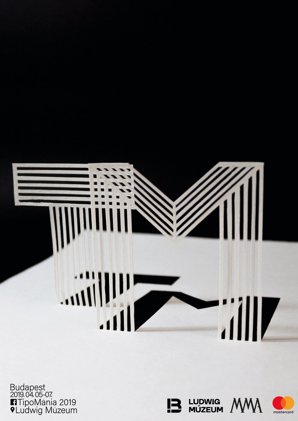 TipoMánia 2019 poster: white paper letters on black