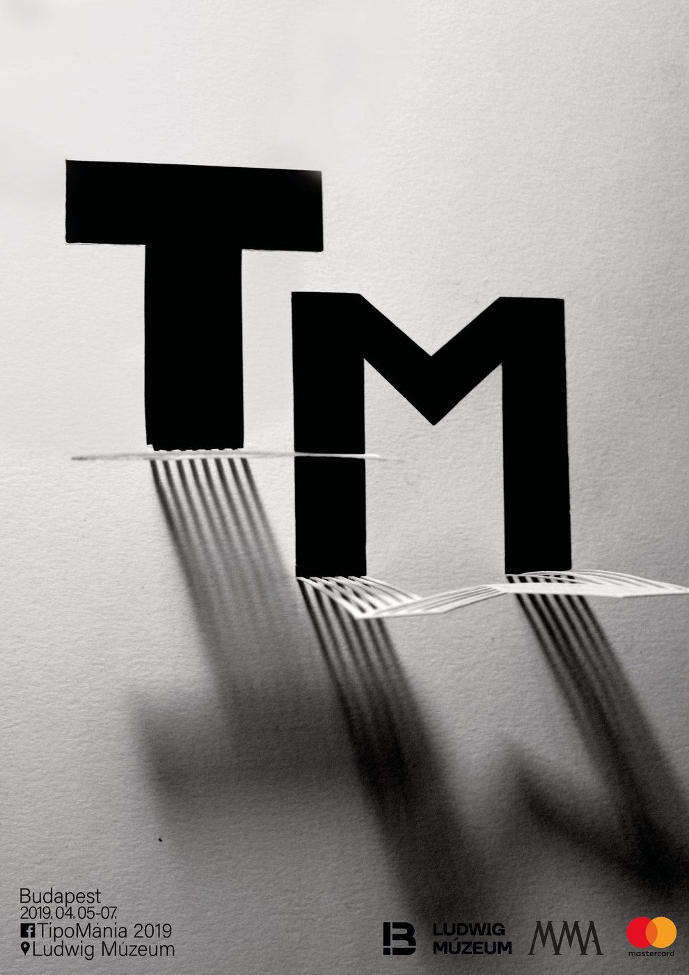TipoMánia 2019 poster: black TM letters casting long shadows