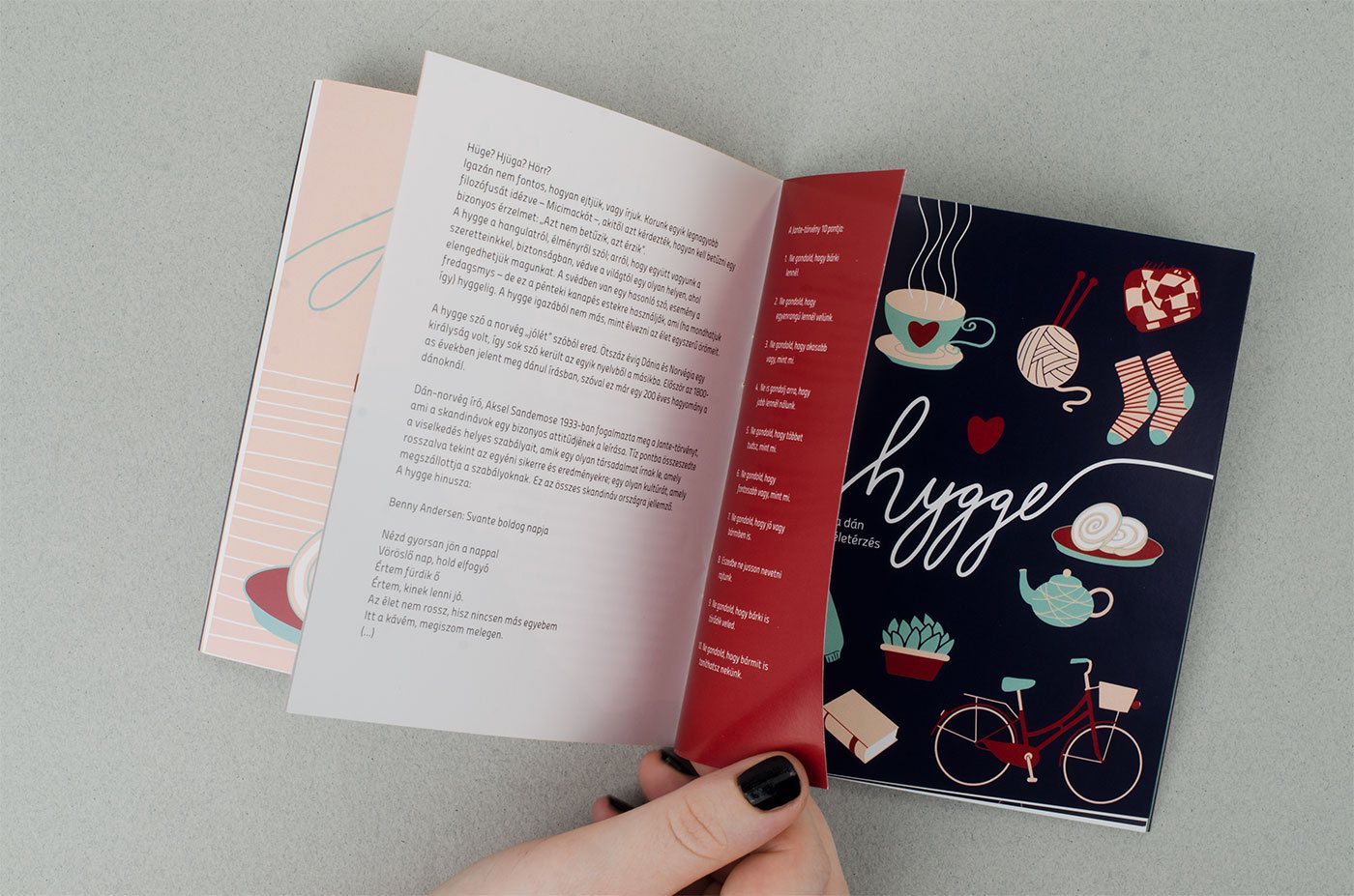 The open booklet on a hygge spread, held next to a cup of coffee