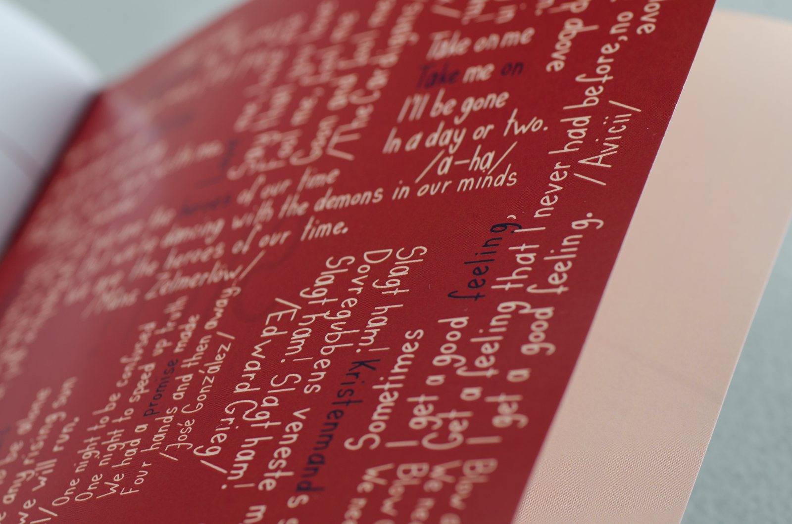 Close-up of a dark red page with hand-lettered text