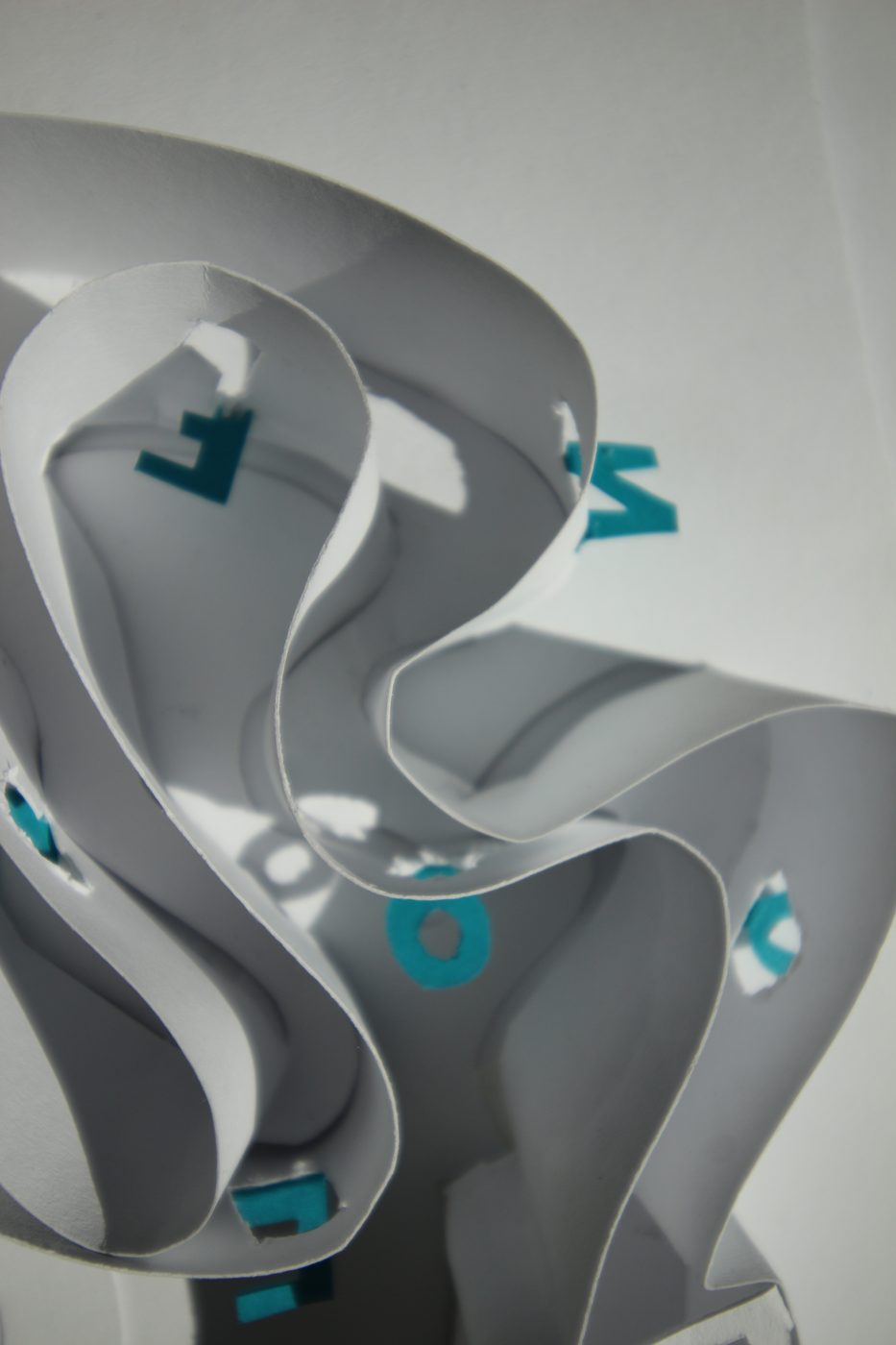 Wavy paper walls with teal letters floating between them